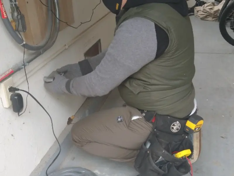 Electrician performing outlet wiring in a McLean garage